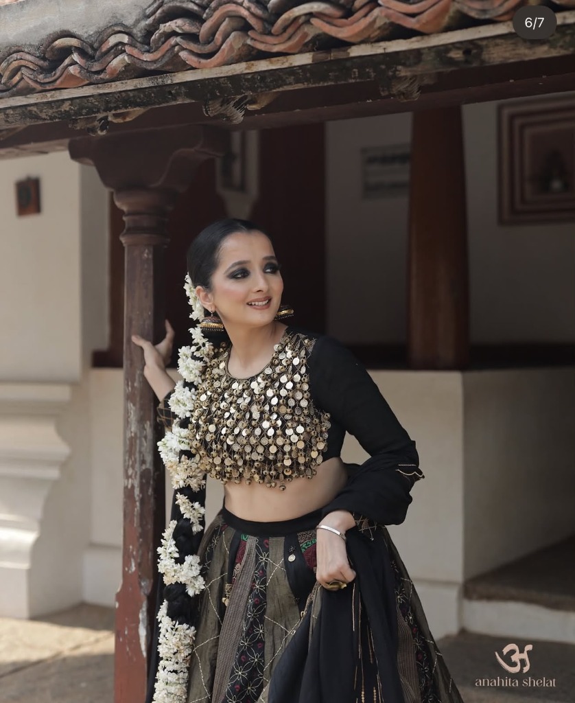 Portrait of a woman wearing an elegant, minimally embellished black and gold Anahita Shelat lehenga, illustrating versatile occasion wear in quiet luxury Indian fashion
